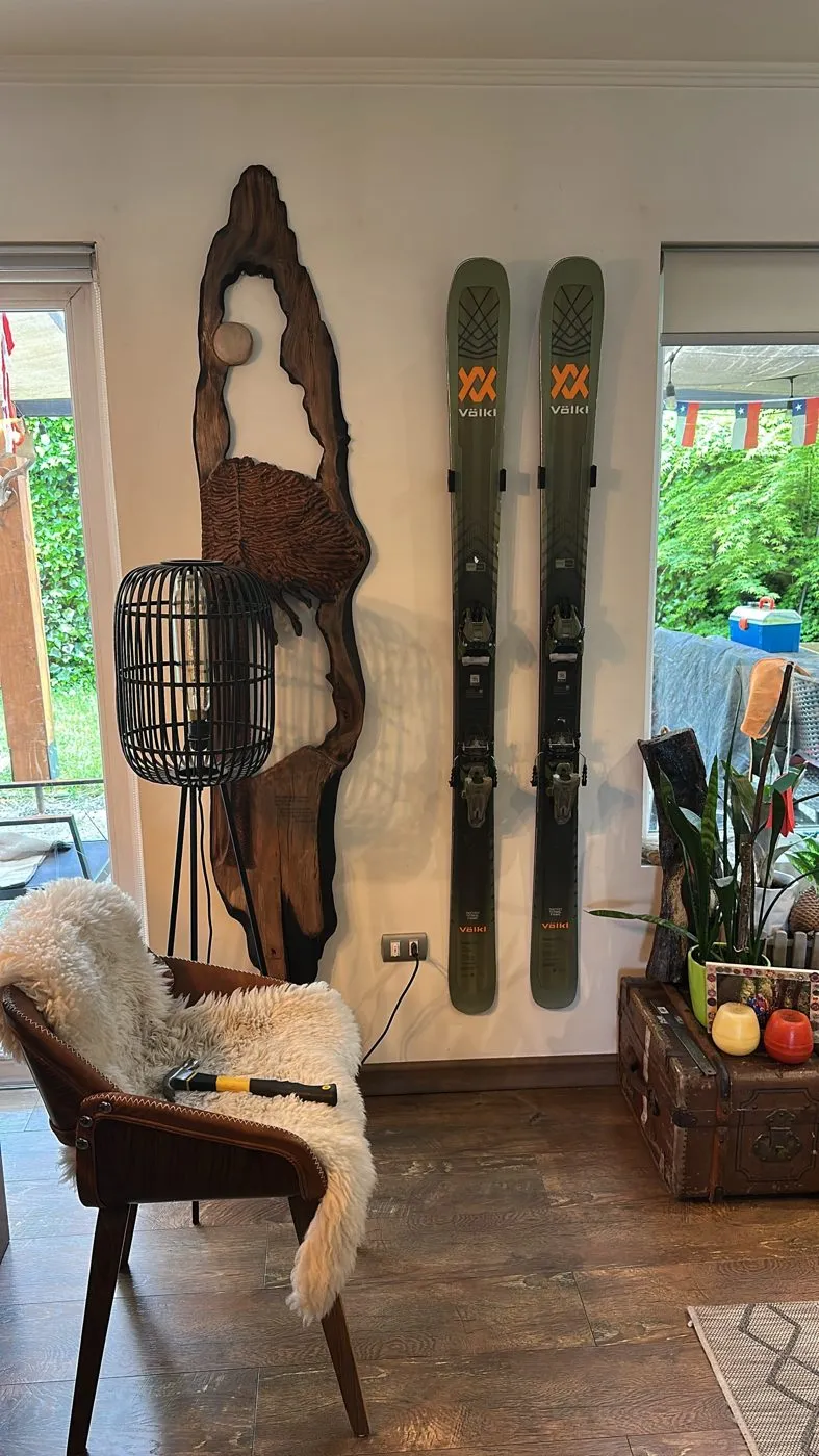Par de skis colgados de frente en el muro de un living con soportes HAIQUE
